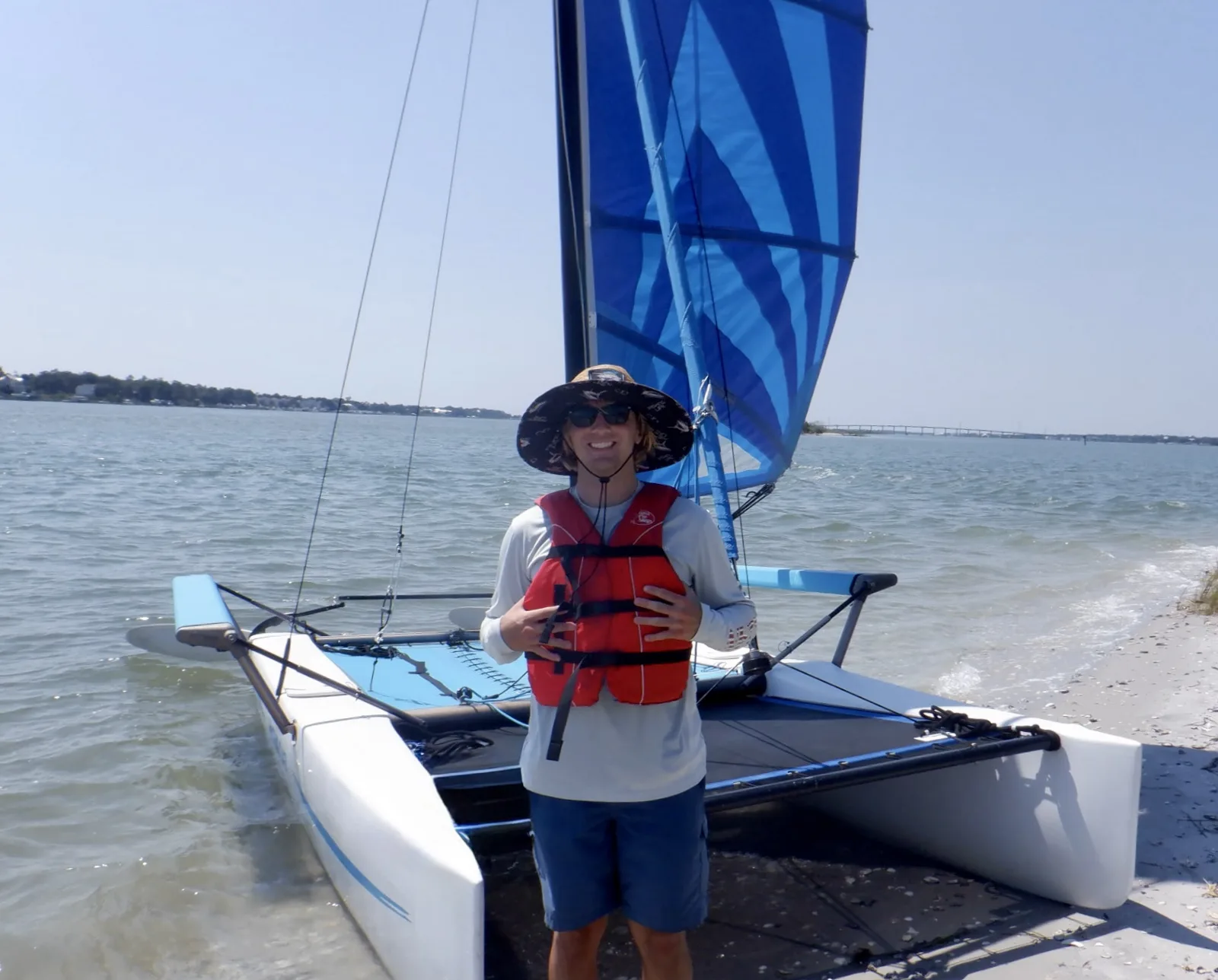 Captain Zach, USCG master captain and sailing instructor, beside a Hobie Cat on the Intracoastal Waterway in Emerald Isle, NC